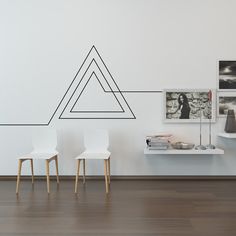 two white chairs sitting next to each other on top of a hard wood floor