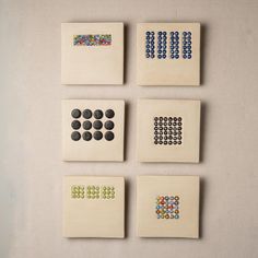 four different colored squares and dots on white paper