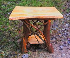 a small wooden table sitting on top of a grass covered field