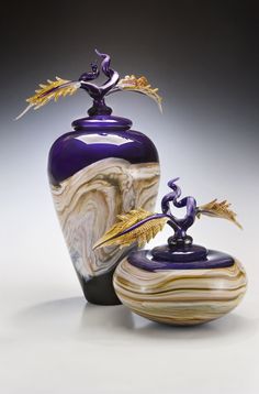 a purple vase sitting on top of a table next to a bird figurine