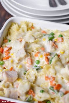 a casserole dish with chicken, peas and carrots in it on a table