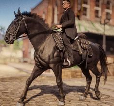 a man riding on the back of a black horse down a cobblestone road