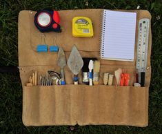 the contents of a tool bag are neatly organized on the grass, including tools and other items