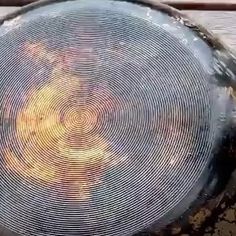 a round metal object sitting on top of a wooden table