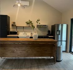 a kitchen with an island in the middle and stainless steel appliances on the other side