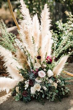 a vase filled with lots of flowers and greenery