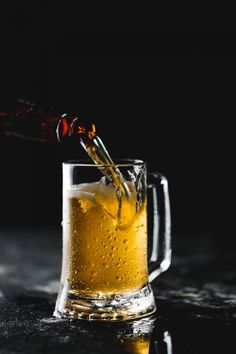 a glass filled with beer being poured into it