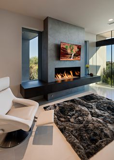 a modern living room with a fireplace and large glass doors that open to the outdoors