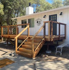 there is a small white house with wooden steps and railings on the front porch