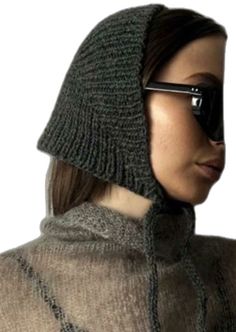 a woman wearing sunglasses and a knitted hat is shown from the neck down to her face