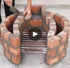 a man is building a fire pit with bricks