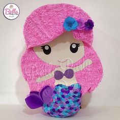 a little mermaid doll with pink hair and purple dress