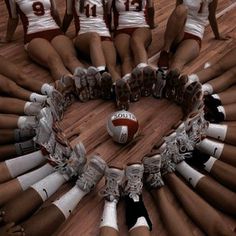 a group of cheerleaders sitting in a circle with their feet on the floor