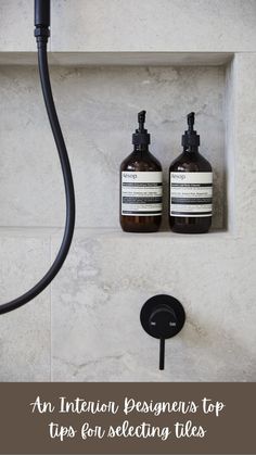 two bottles of hand soap sitting on top of a shelf next to a faucet