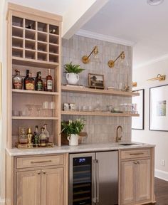 a kitchen with wooden cabinets and shelves filled with bottles