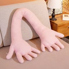 two pink hands are placed on the back of a couch in front of a lamp