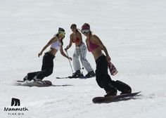 three snowboarders are skiing down a snowy hill