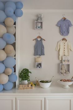 a baby's first birthday party with balloons and decorations on the wall above it