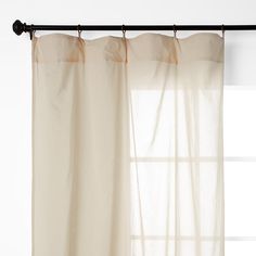 the curtain is hanging in front of an open window with sheer drapes on it