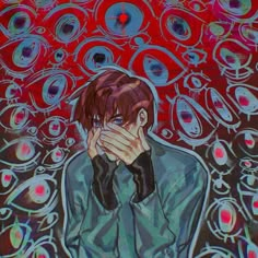 a man covers his face with his hands in front of an image of many circles