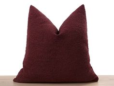 a red pillow sitting on top of a wooden table