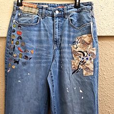 a pair of jeans with patches and buttons on them