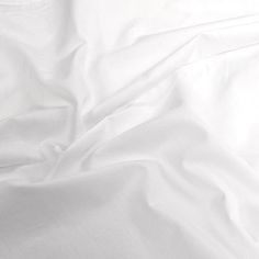 an unmade bed with white sheets and pillows