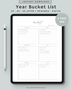 the printable year bucket list is displayed on a clipboard next to a pen