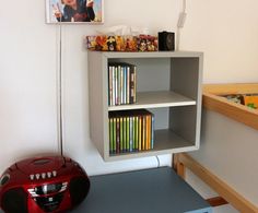 there is a book shelf with many books on it and a radio next to it