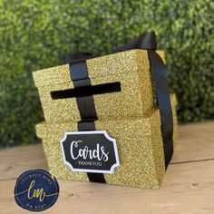 a gold gift bag with black ribbon and name tag that says cord's thank you