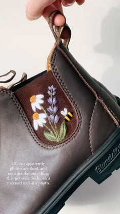 someone is holding the inside of a shoe with flowers on it