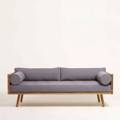 a gray couch sitting on top of a wooden frame