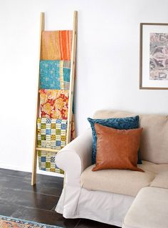 a white couch sitting next to a wooden ladder