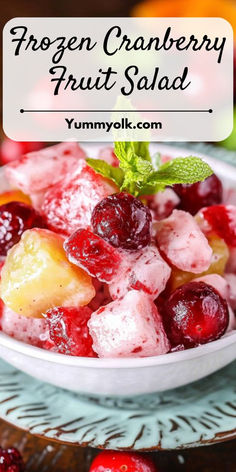 frozen cranberry fruit salad in a white bowl with mint leaves on the side