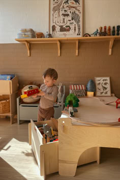 a young boy playing with toys in his playroom