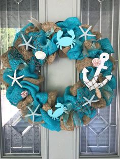 a blue wreath with an anchor, starfish and seahorse on the front door