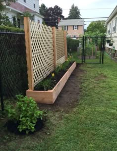 a fenced in garden with flowers and plants growing out of the planter boxes