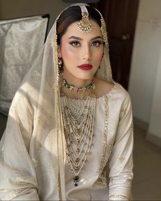 a woman wearing a bridal outfit and jewelry