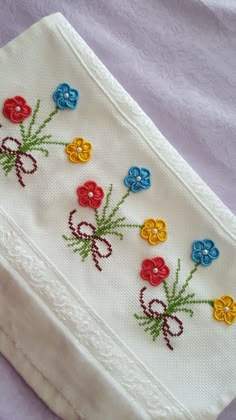 a close up of a cloth with flowers embroidered on the front and back of it