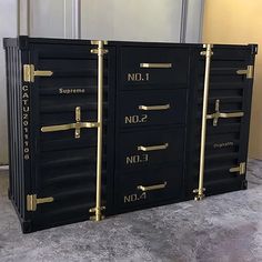 three black drawers with gold handles and numbers on them, sitting next to each other