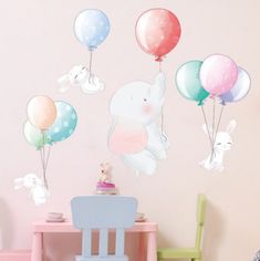 a child's room with pink walls and pastel colored balloons in the shape of animals