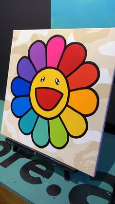 a colorful flower painted on top of a wooden table