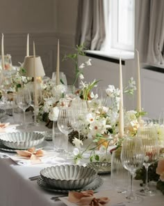 the table is set with flowers and candles