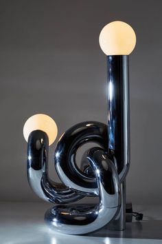 a lamp that is sitting on top of a metal stand with two lights in it