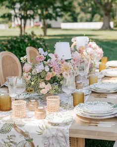 the table is set with flowers and plates