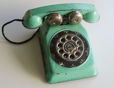 an old green phone with two bells on the front and one bell on the back