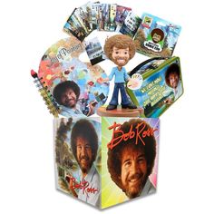 an assortment of bob ross toys and books