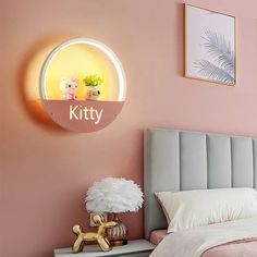 a bedroom with pink walls and white bedding has a lit up kitty sign on the wall