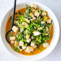 a white bowl filled with tofu and peas