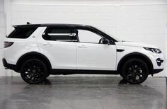 a white land rover is parked in a garage